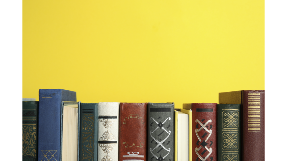 Mehrere Bücher vor gelbem Hintergrund zeigen das Literaturverzeichnis der Lehrkräftefortbildung